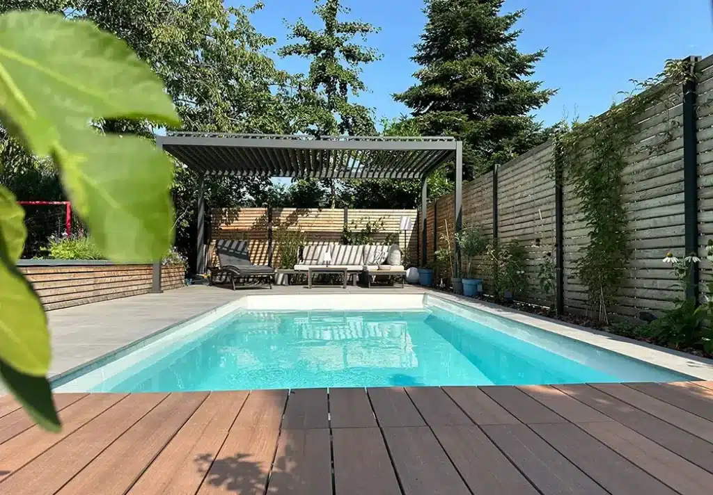 Gepflegter Gartenpool mit Holzterrasse und Pergola