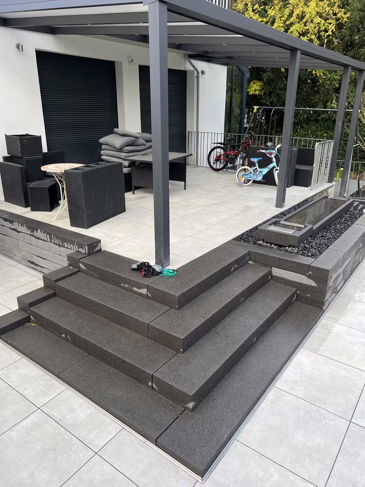 Terrasse aus großformatigen Platten mit dunkler Blockstufen-Treppe in Frankfurt