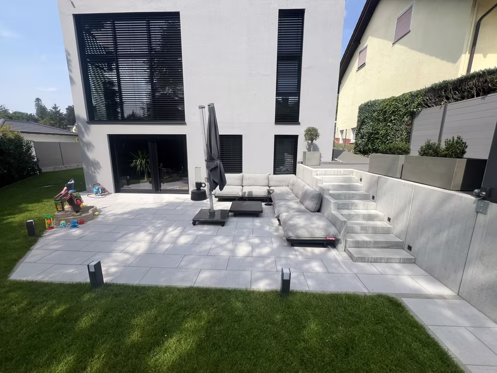 Neue Terrasse mit Treppe aus Blockstufen in einem Neubaugarten in Kronberg